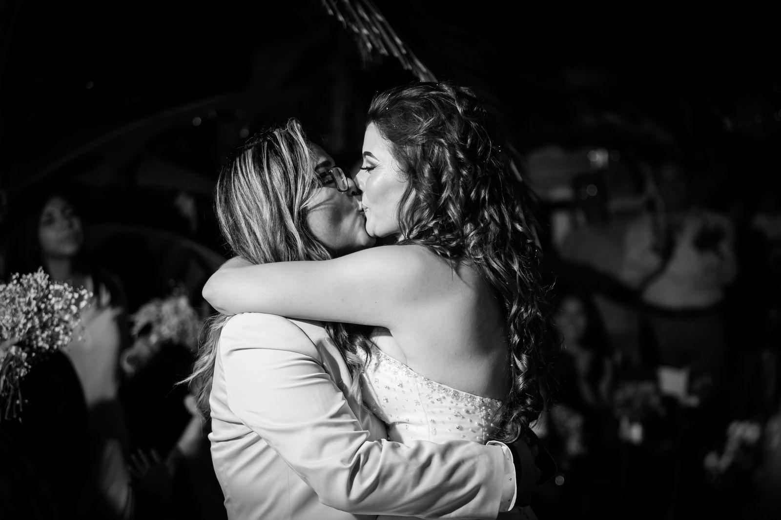 Two brides sharing a kiss at their wedding reception