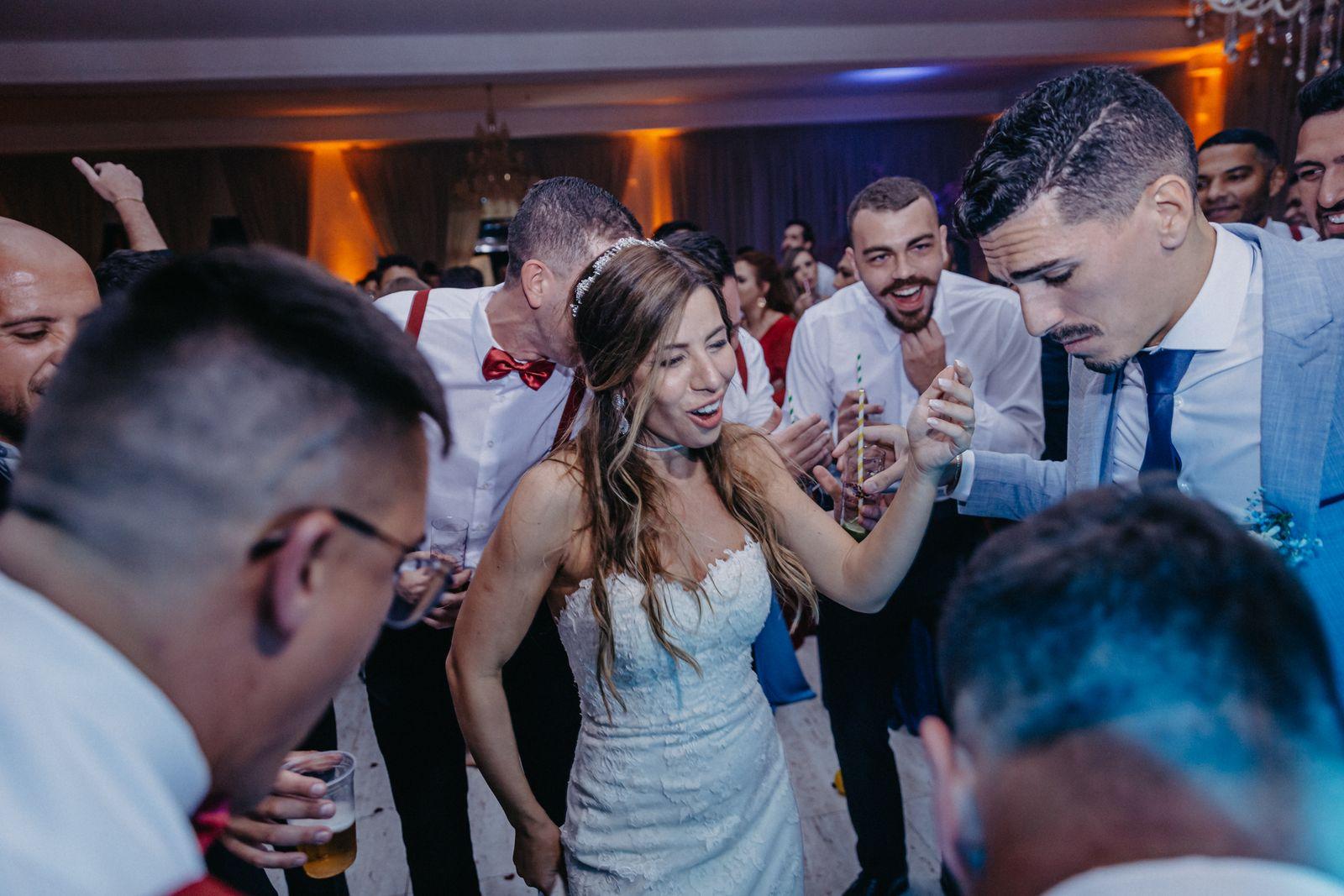 Newlyweds dancing surrounded by their wedding guests
