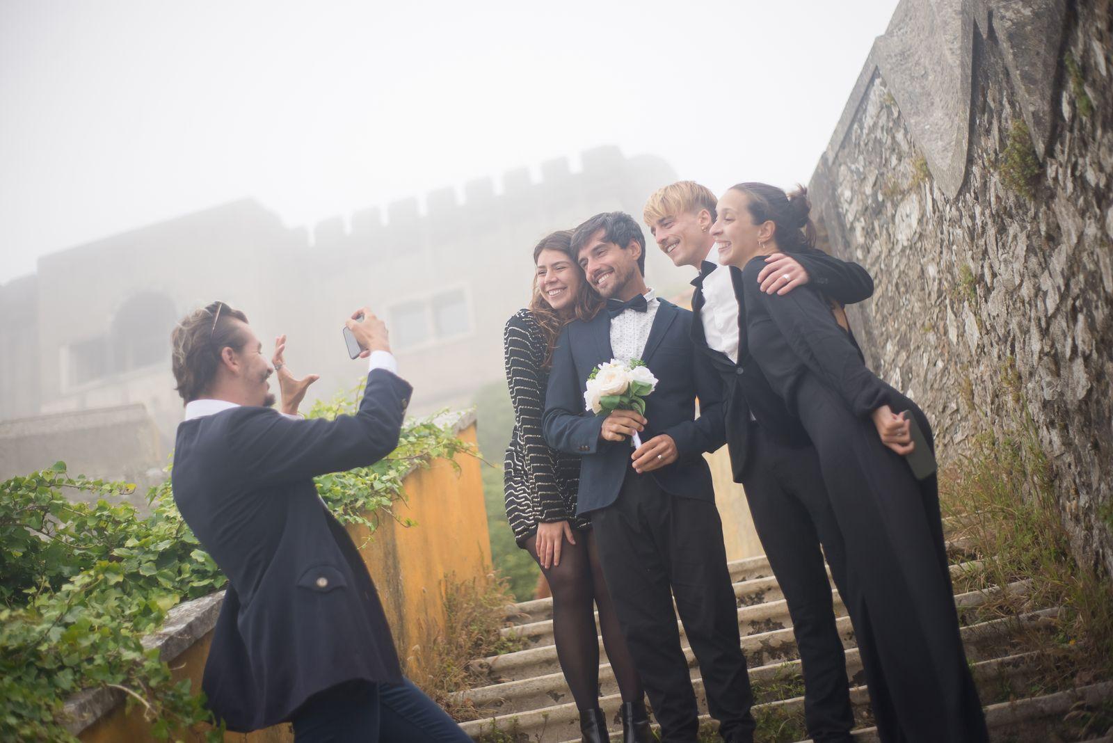 A wedding guest photographing friends together on stone steps