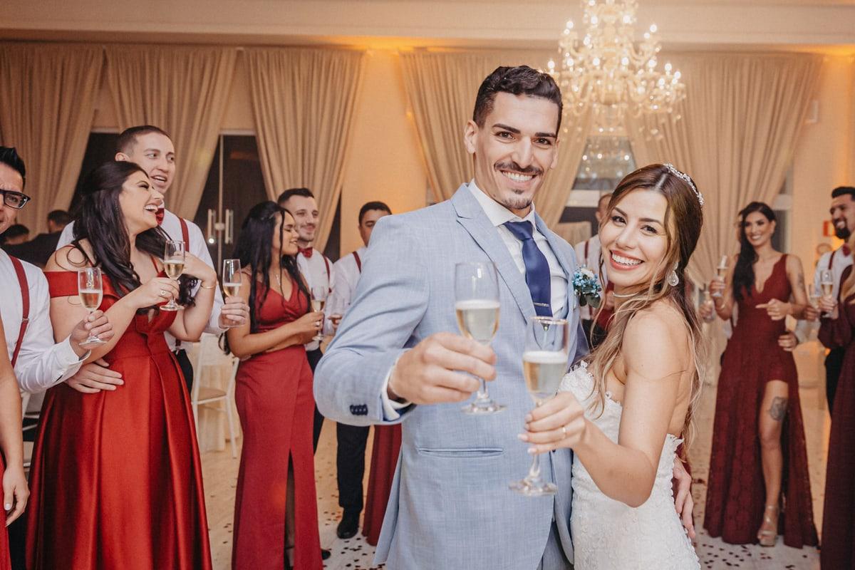 Newlyweds raising champagne glasses with their wedding guests